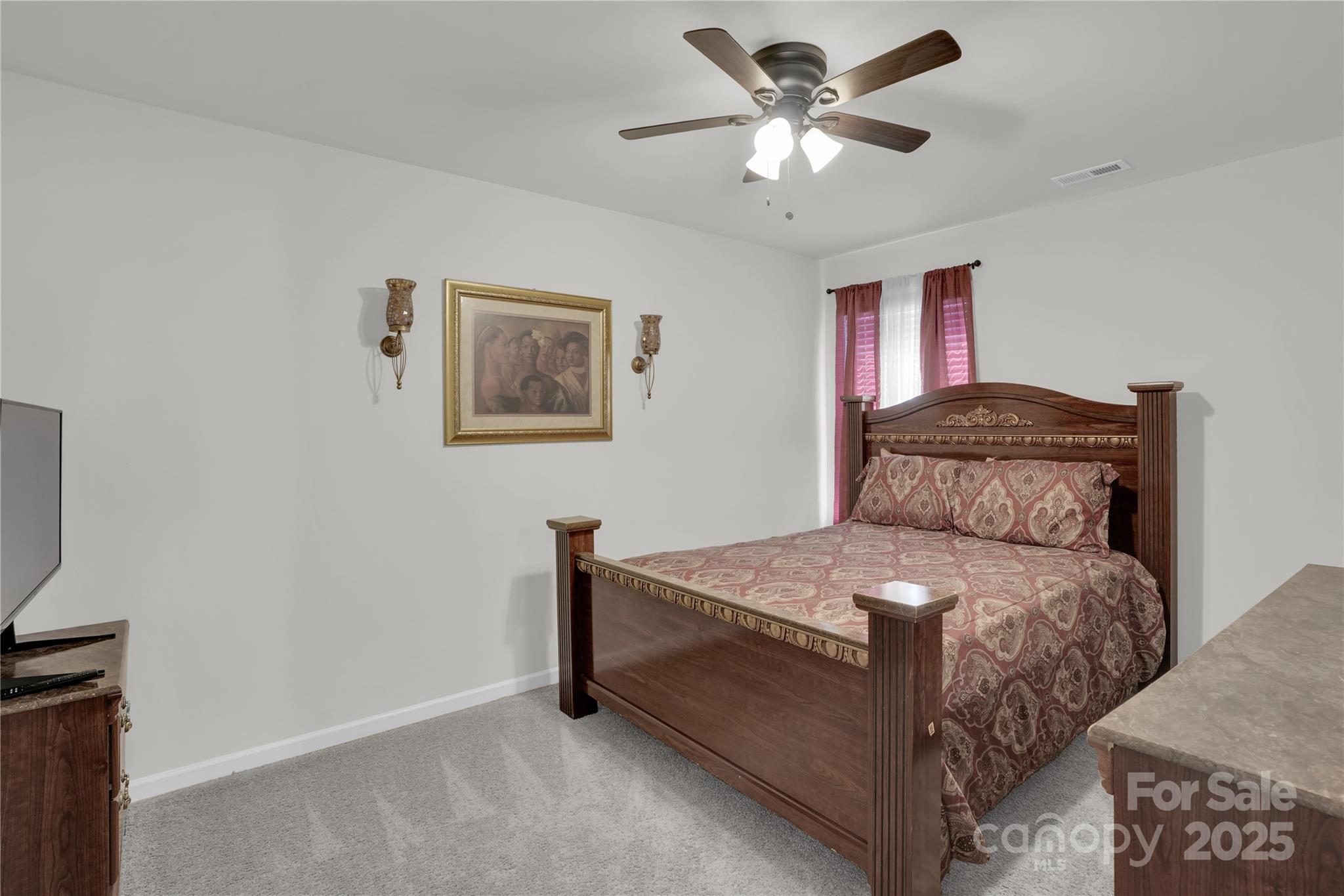 4918 Traynor Road Charlotte, NC 28216 - Photo 13 of 27 a bedroom with a bed and a ceiling fan