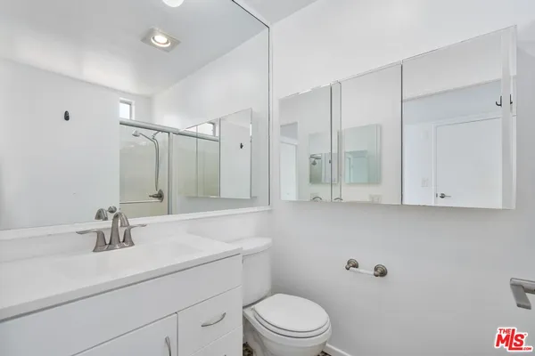 a bathroom with a sink a toilet and mirror