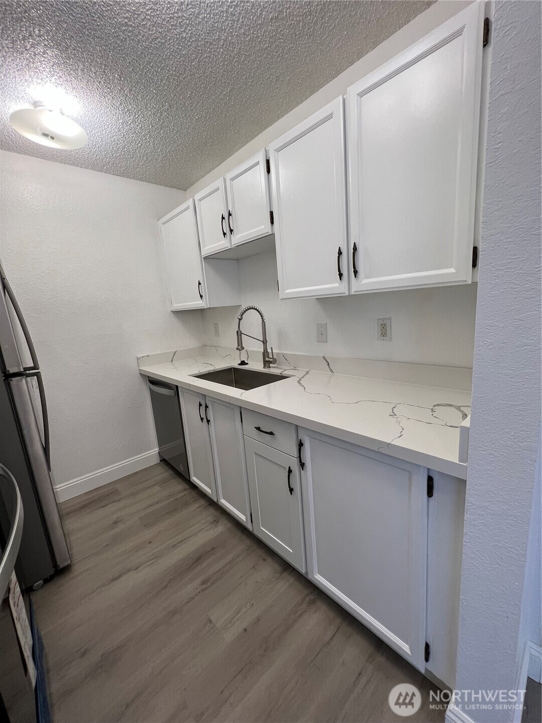 1175 Harrington Place Northeast, Unit 214 Renton, WA 98056 - Photo 12 of 16 a kitchen with cabinets a sink and appliances