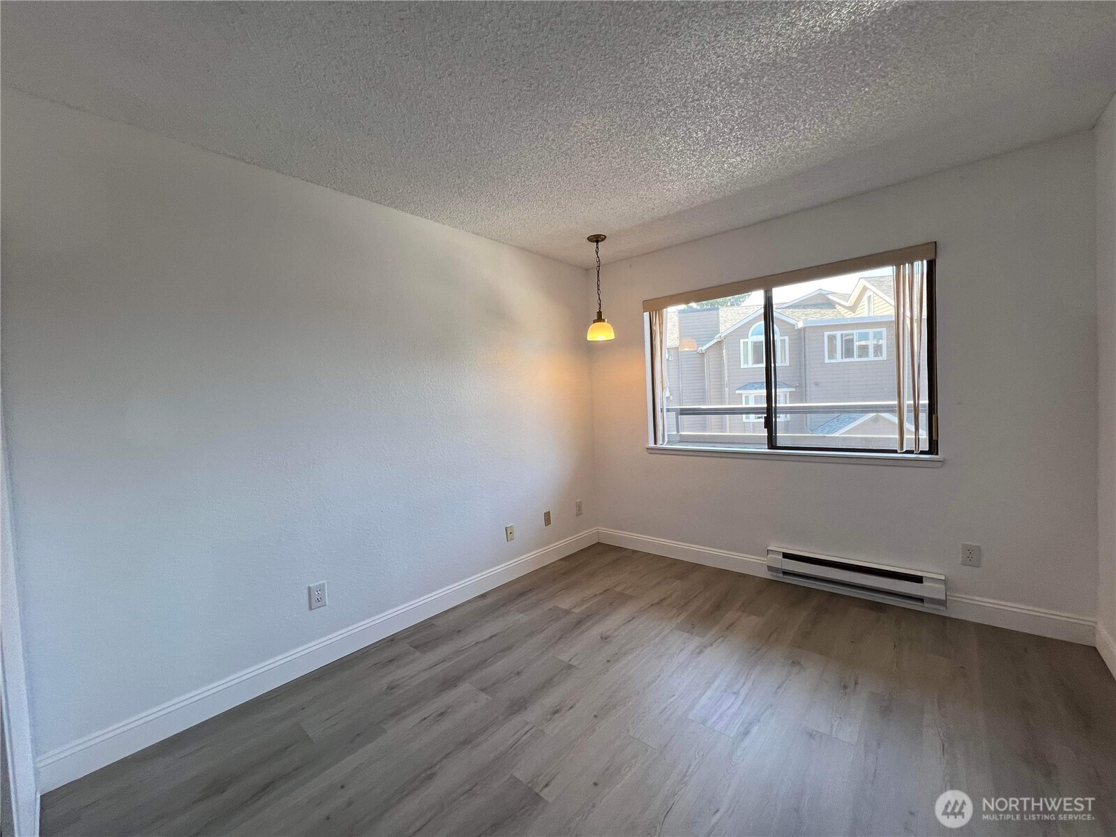 1175 Harrington Place Northeast, Unit 214 Renton, WA 98056 - Photo 4 of 16 an empty room with wooden floor and windows