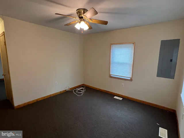a view of an empty room with a chandelier fan