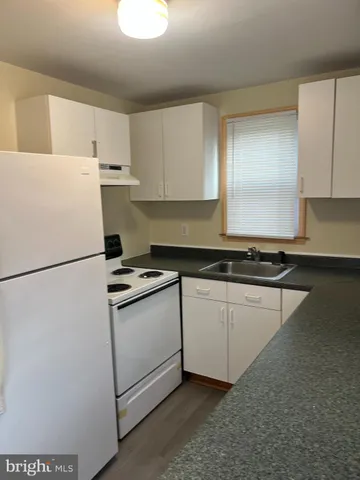 a kitchen with appliances a sink and a refrigerator