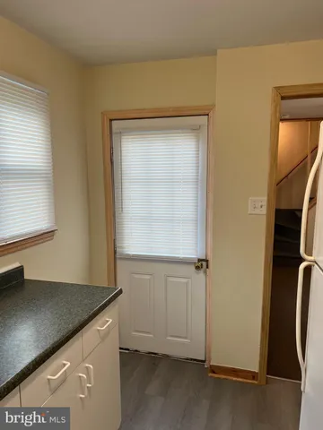 an entryway with wooden floor and cabinet