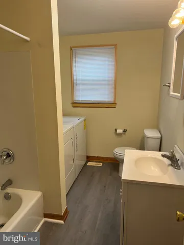 a bathroom with a sink and mirror with toilet