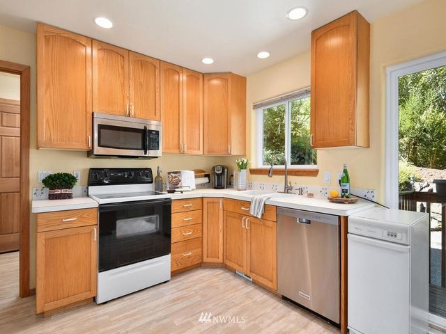a kitchen with a sink cabinets appliances and a window