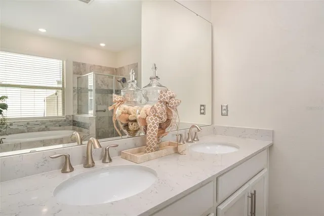 a bathroom with a granite countertop sink and a bathtub