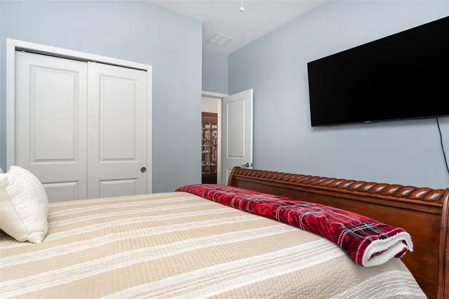 a bedroom with a bed and a flat screen tv