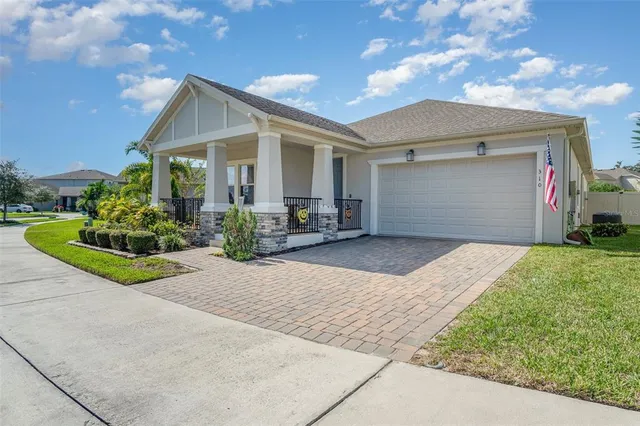 a front view of a house with a yard and potted plants