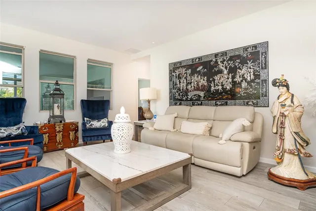 a living room with furniture a flat screen tv and a floor to ceiling window