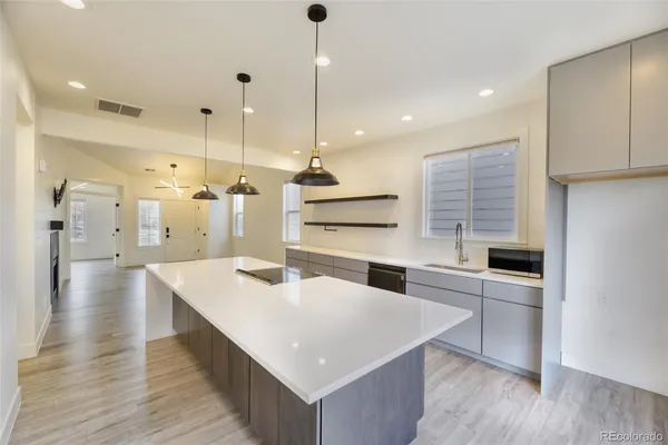 a large kitchen with stainless steel appliances kitchen island a cabinets and wooden floor
