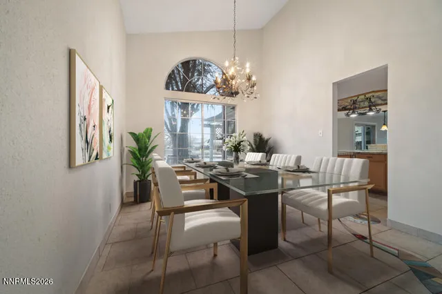 a view of a dining room with furniture a chandelier and a window