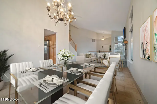 a living room with furniture a chandelier and a dining table
