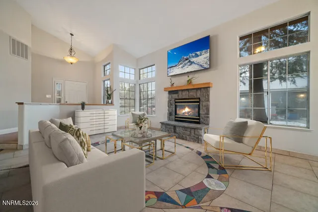 a living room with furniture a fireplace and a flat screen tv