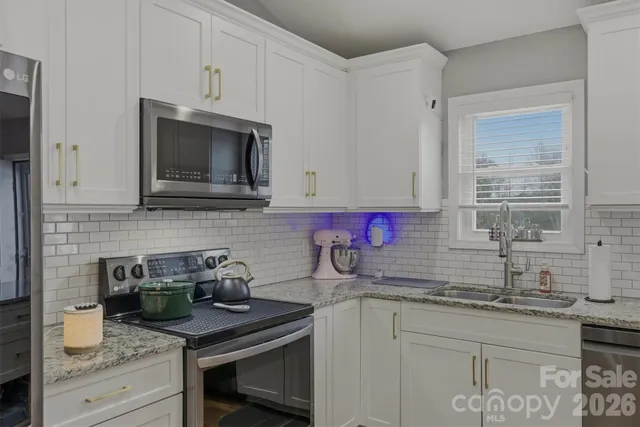 a kitchen with sink a microwave and cabinets