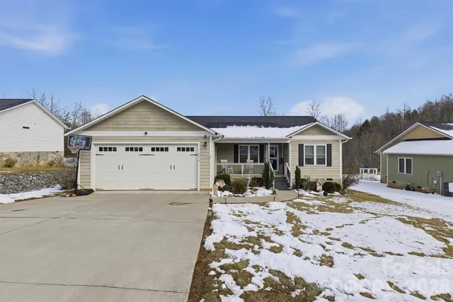 a view of a house with snow on the side of the road