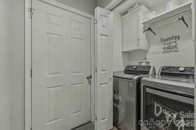 a view of a kitchen with white cabinets and stainless steel appliances