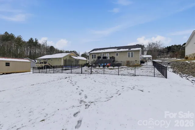 a backyard of a house with table and chairs under an umbrella