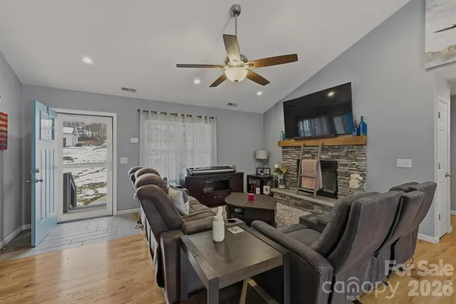 a living room with furniture a fireplace and a flat screen tv