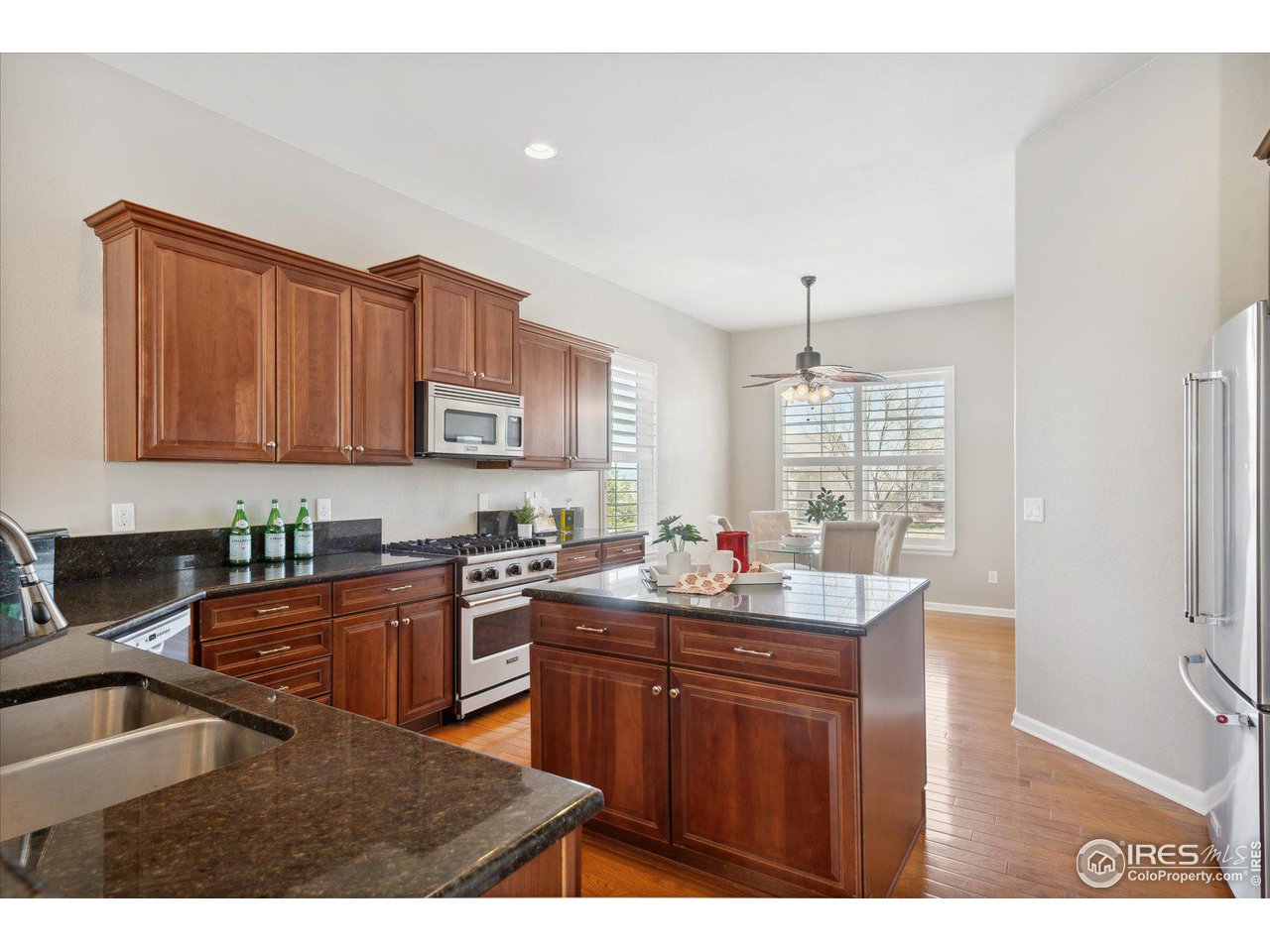 4514 Silver Mountain Loop Broomfield, CO 80023 - Photo 9 of 39 a kitchen with granite countertop a sink stove and cabinets