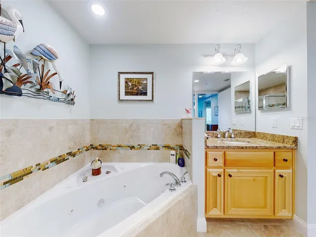 a bathroom with a granite countertop sink toilet mirror and bathtub