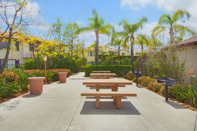 a view of a patio with couches table and chairs potted plants and palm trees