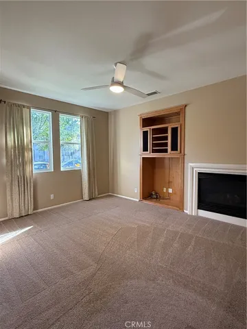 a view of an empty room with a fireplace and a window