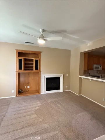 a view of an empty room with a fireplace and a window