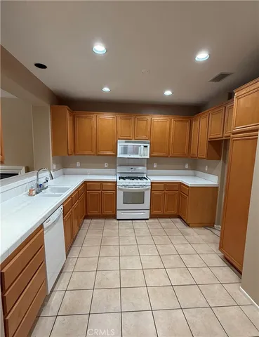 a kitchen with a sink a stove top oven and cabinets