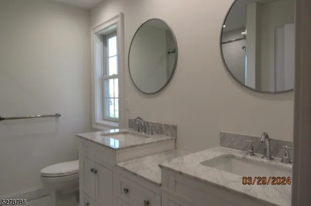 a bathroom with a granite countertop toilet sink and mirror