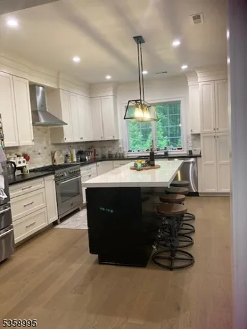 a kitchen with kitchen island granite countertop a sink a counter top space appliances and cabinets