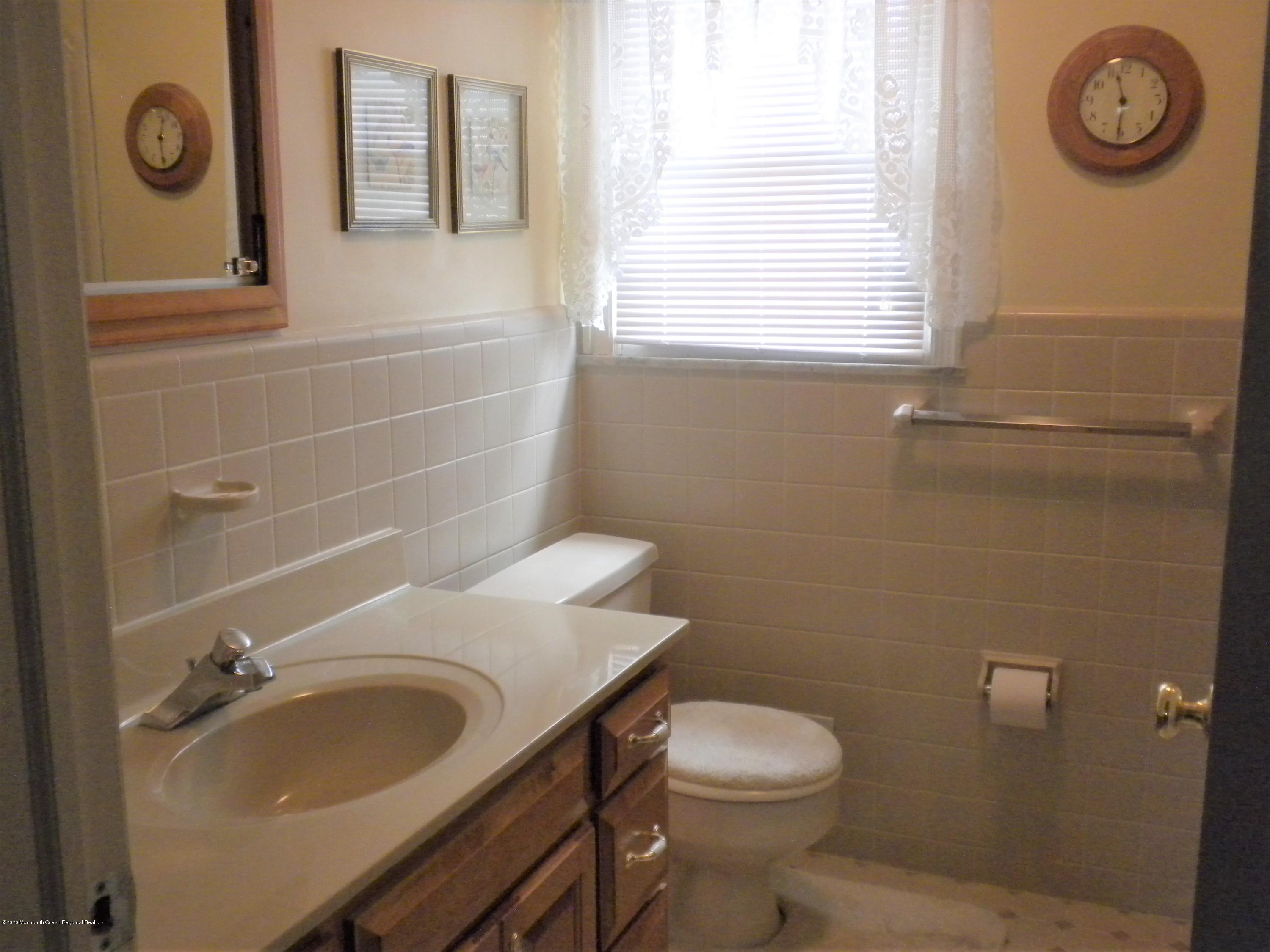 28 Ridge Road West Long Branch, NJ 07764 - Photo 13 of 19 a bathroom with a granite countertop toilet a sink and mirror