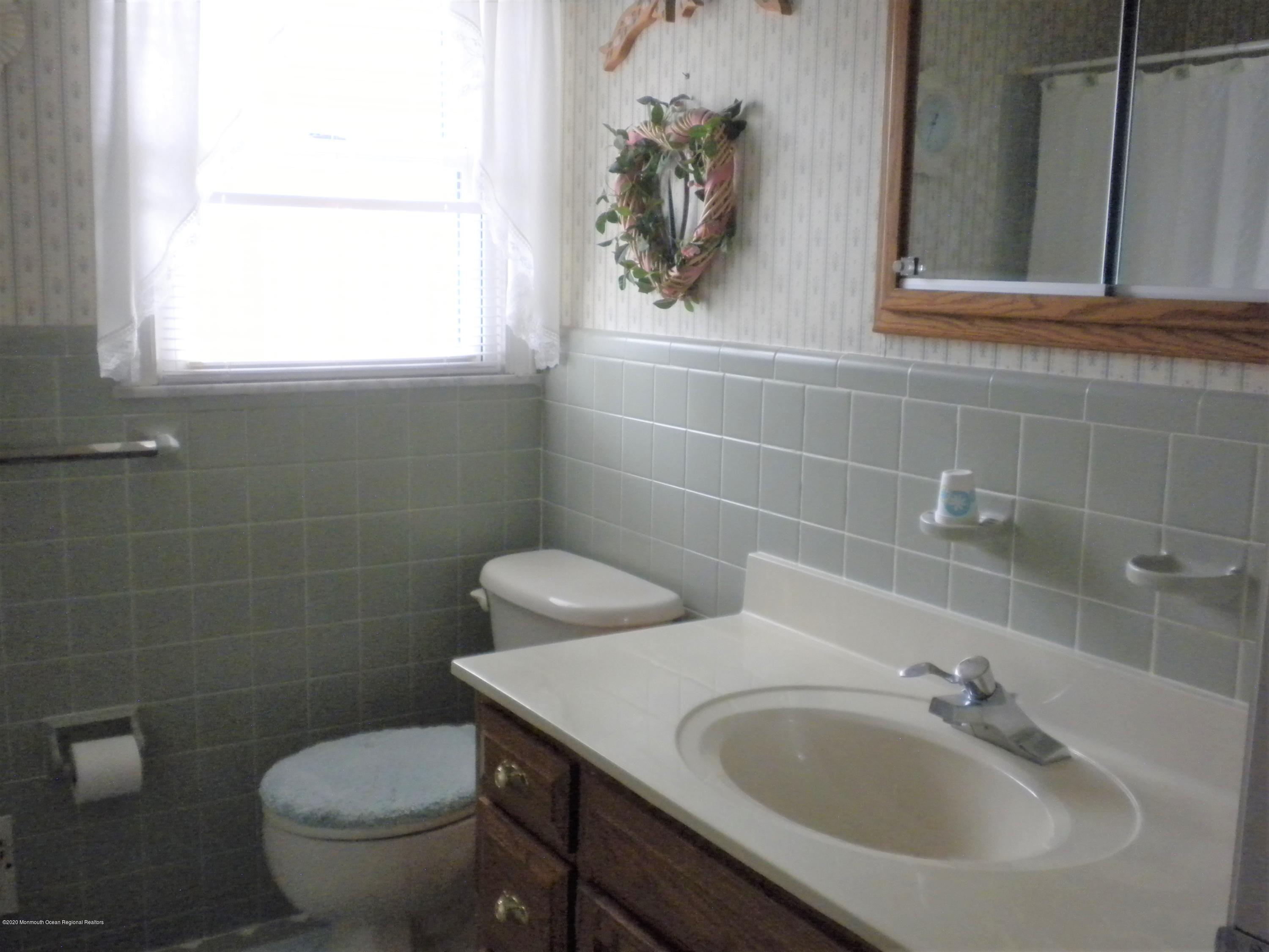 28 Ridge Road West Long Branch, NJ 07764 - Photo 15 of 19 a bathroom with a sink a toilet and a mirror