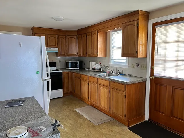 a kitchen with stainless steel appliances granite countertop a refrigerator sink and window