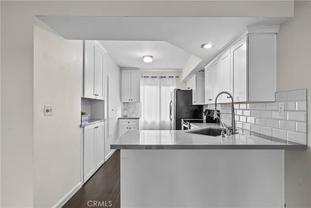 a kitchen with stainless steel appliances granite countertop a sink and a refrigerator
