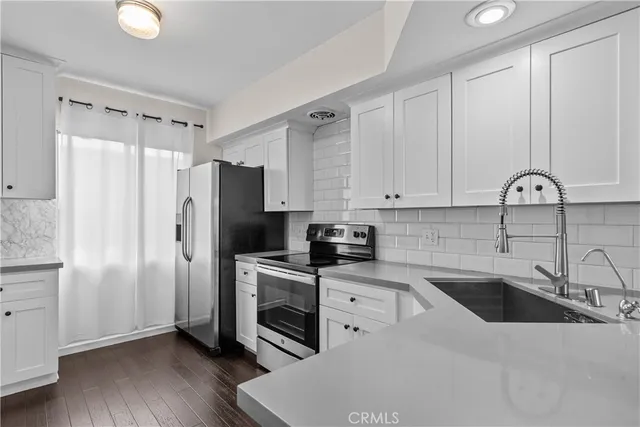 a kitchen with stainless steel appliances a refrigerator sink and cabinets