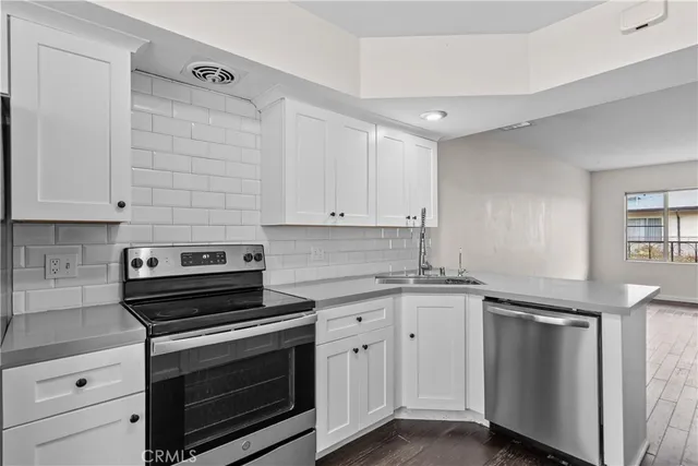 a kitchen with granite countertop a stove sink and cabinets