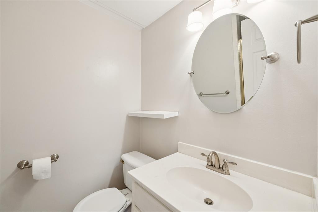 4511 Gilbert Avenue, Unit 103 Dallas, TX 75219 - Photo 18 of 35 a bathroom with a sink mirror and toilet