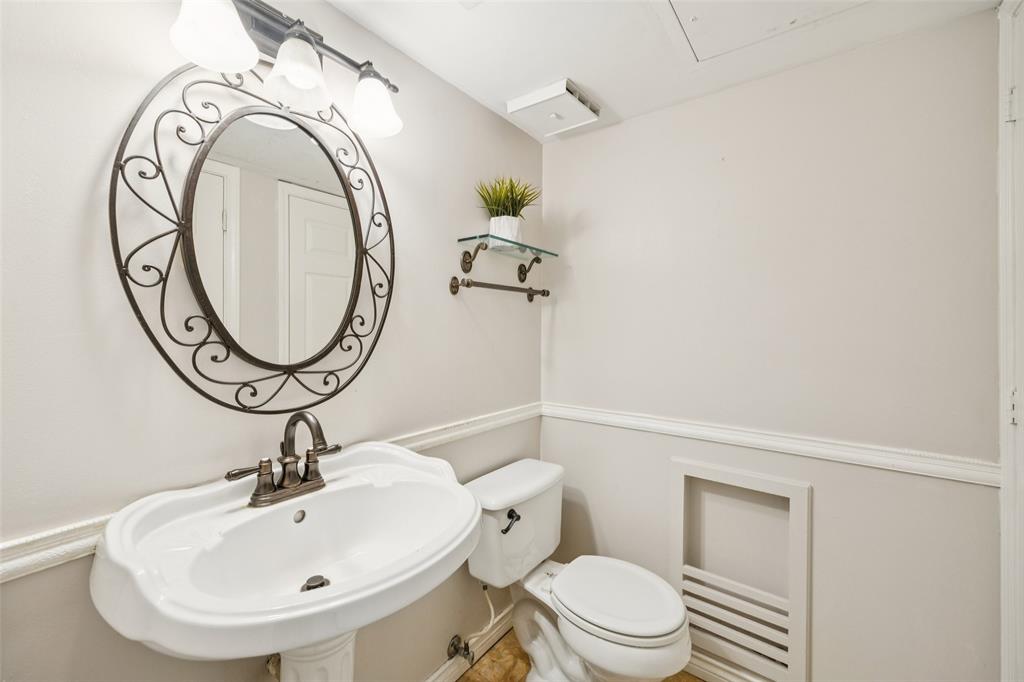 4511 Gilbert Avenue, Unit 103 Dallas, TX 75219 - Photo 23 of 35 a bathroom with a sink a toilet and a mirror