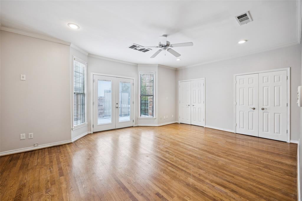 4511 Gilbert Avenue, Unit 103 Dallas, TX 75219 - Photo 9 of 35 a view of an empty room with wooden floor and a window