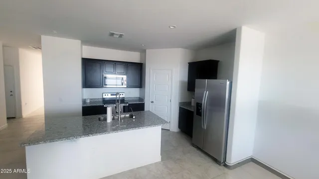 a kitchen with stainless steel appliances granite countertop a refrigerator and a stove