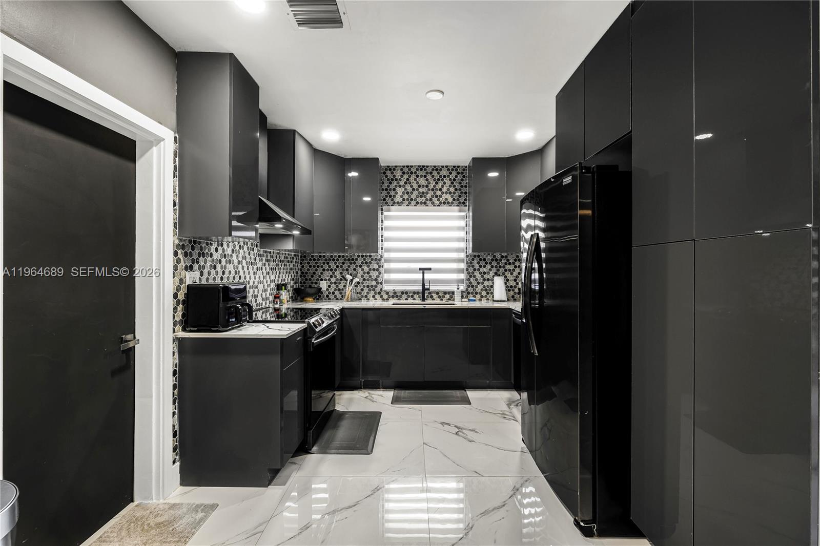 285 Northwest 45th Street Miami, FL 33127 - Photo 15 of 39 a kitchen with a sink and refrigerator