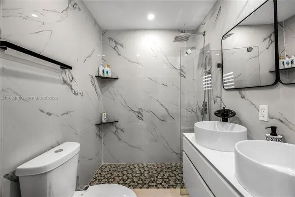 a bathroom with a toilet a sink and mirror