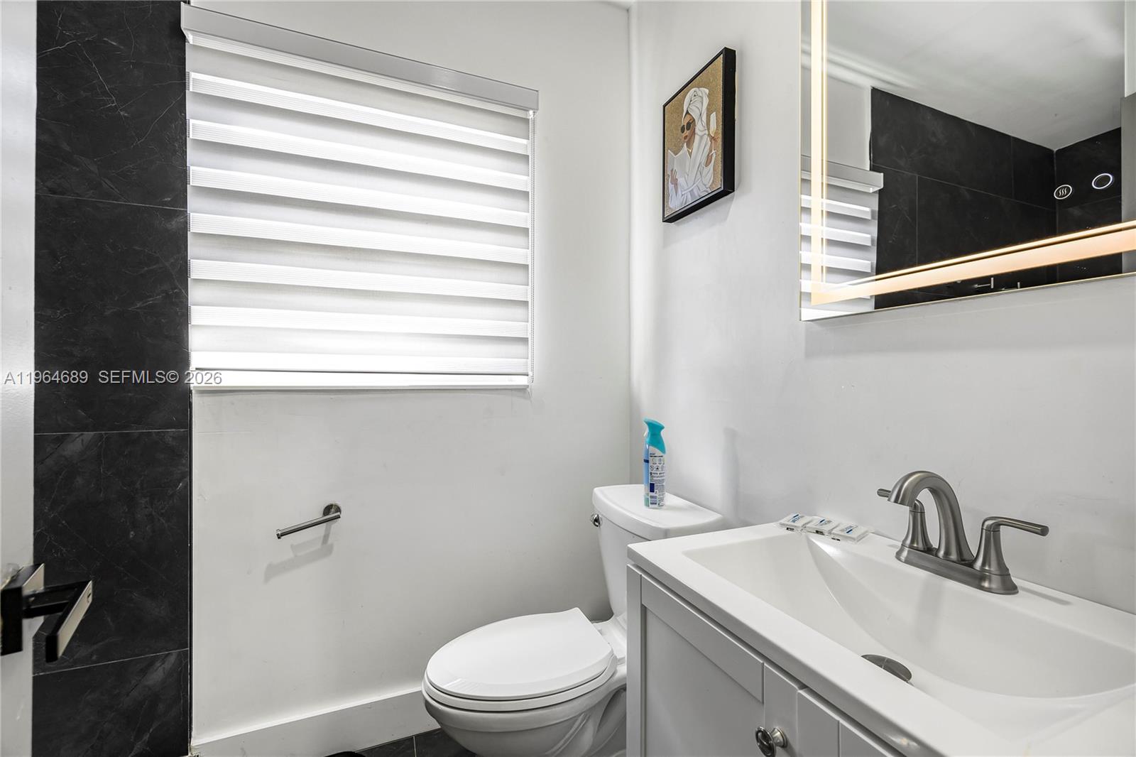 285 Northwest 45th Street Miami, FL 33127 - Photo 24 of 39 a bathroom with a toilet a sink and mirror