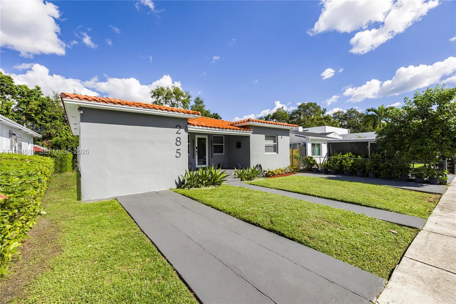 285 Northwest 45th Street Miami, FL 33127 - Photo 4 of 39 a front view of a house with a yard and garage