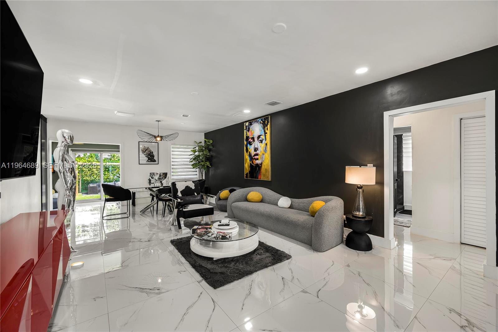 285 Northwest 45th Street Miami, FL 33127 - Photo 7 of 39 a living room with furniture and a flat screen tv