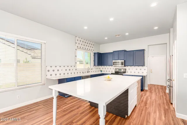 a kitchen with stainless steel appliances a table and chairs in it