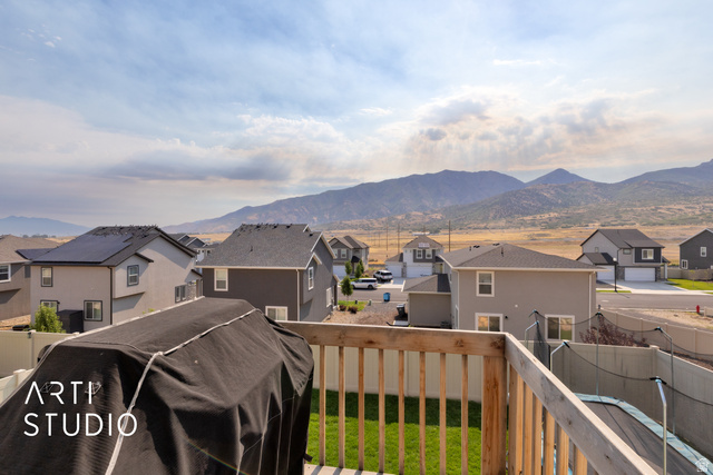 1713 South Windemere Road Santaquin, UT 84655 - Photo 32 of 40 Wood railing on an upper-level deck overlooking a residential area with mountain scenery