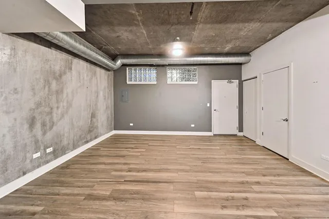 a kitchen with stainless steel appliances granite countertop a refrigerator a stove top oven a sink dishwasher a dining table and chairs with wooden floor