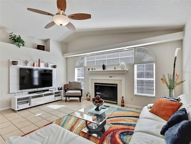 a living room with furniture a flat screen tv and a fireplace