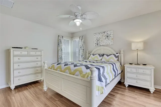 a bedroom with a bed and a ceiling fan